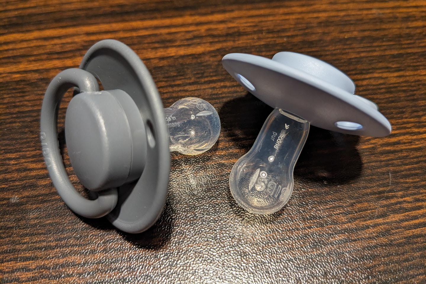 a pair of pacifiers sitting on top of a wooden table