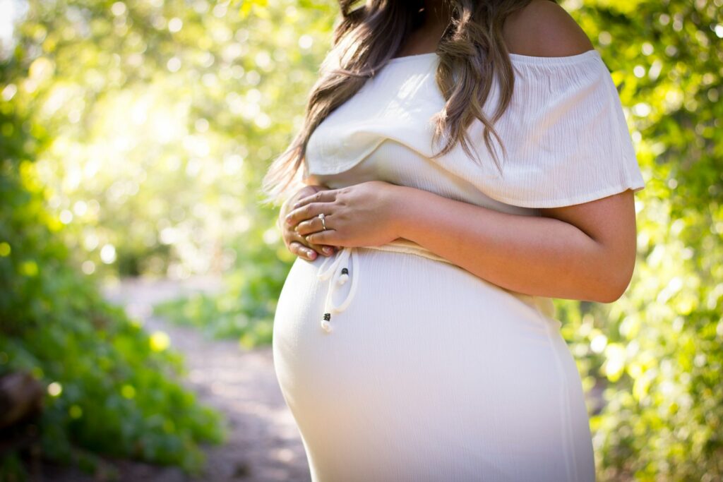 Femme enceinte debout au milieu de plantes vertes