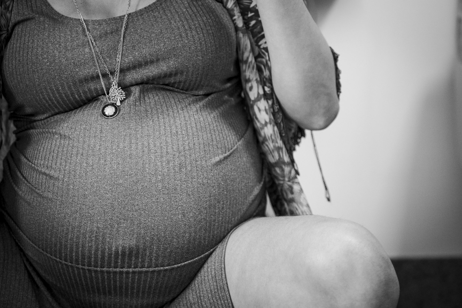 Femme enceinte assise sur un fauteuil, la main sur le ventre